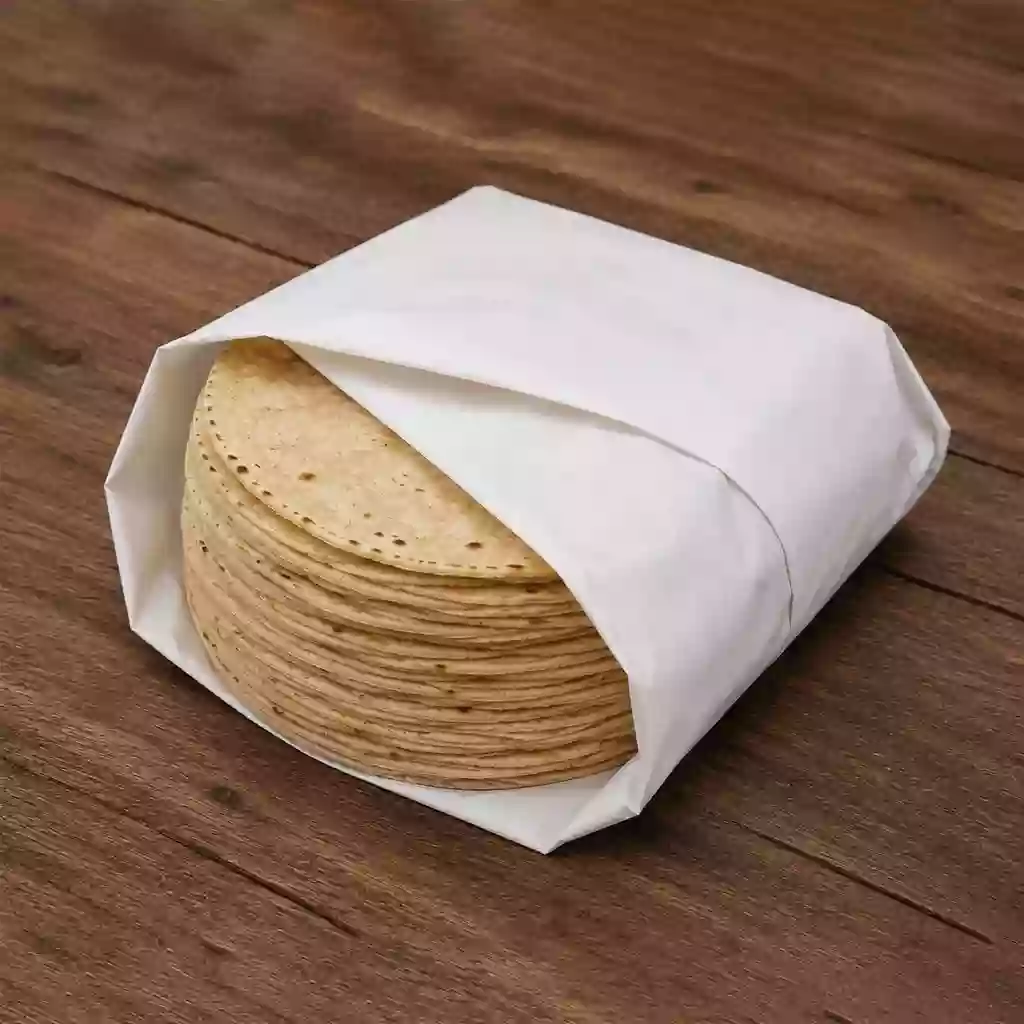 Tortillas envueltas en papel grado alimenticio - PAPELVER - PAPELVER Tortillas de maíz envueltas en papel grado alimenticio sobre mesa de madera